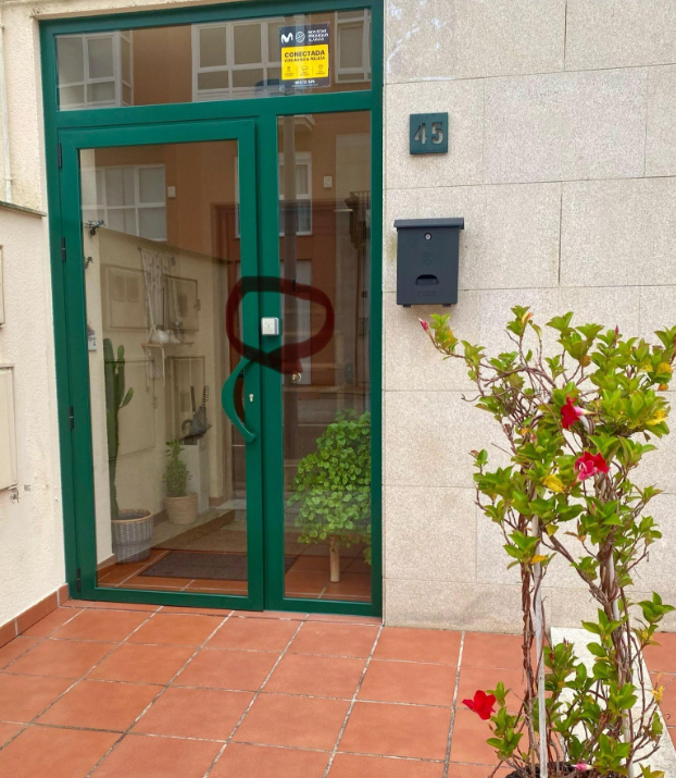 Puerta de entrada verde y timbre gris